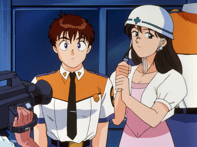 Noa Izumi fields questions from a reporter in a scene from the Patlabor the Mobile Police TV series.