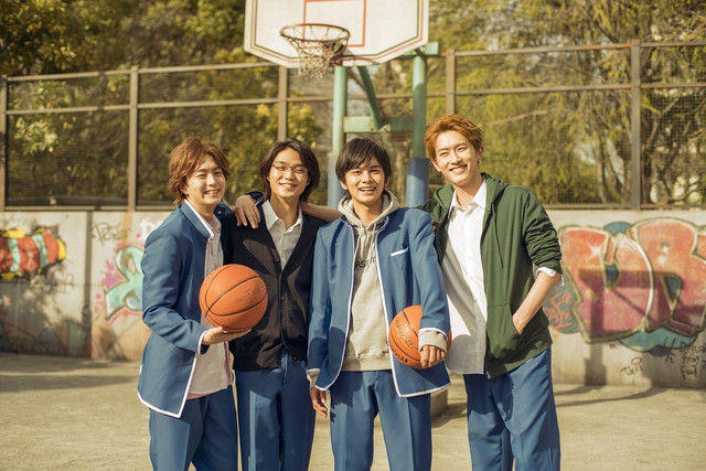 الشباب الأربعة في ساحة كرة السلة وممسكين بكرتين وهم مبتسمين ومرتدين ملابس مدرسية