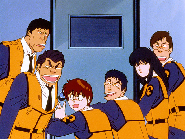The crew of Special Vehicles Section 2 is caught eavesdropping in a scene from the Patlabor the Mobile Police TV series.