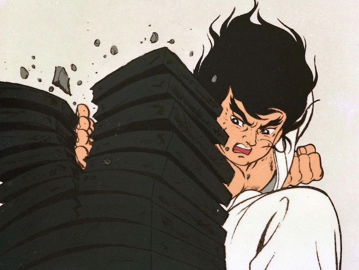 Ichidai breaks a stack of ceramic roof tiles with a powerful karate chop in a promotional image for the 1973 - 1974 Karate Master TV anime.