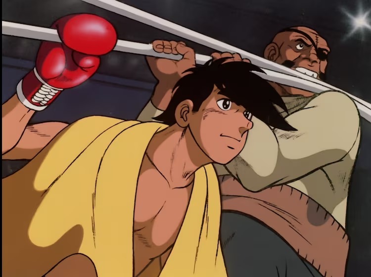 With the help of his trainer, Danpei Tange, Joe steps between the ropes for a boxing match in a scene from the 1970 - 1971 TV anime, Ashita no Joe.