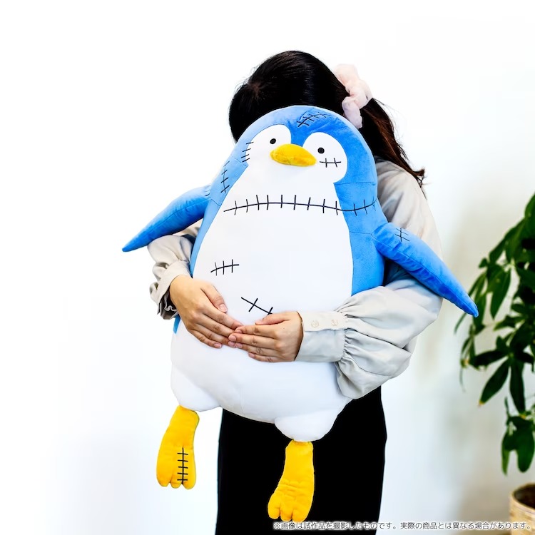 A promotional image of the SPY x FAMILY "Penguin Plush Toy" featuring a model lifting up and lovingly embracing the toy from behind.