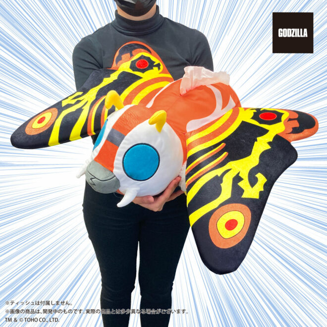A promotional image for the Mothra (Imago) Tissue Case product from Premium Bandai, featuring a dynamic close-up view of a model holding the finished product.