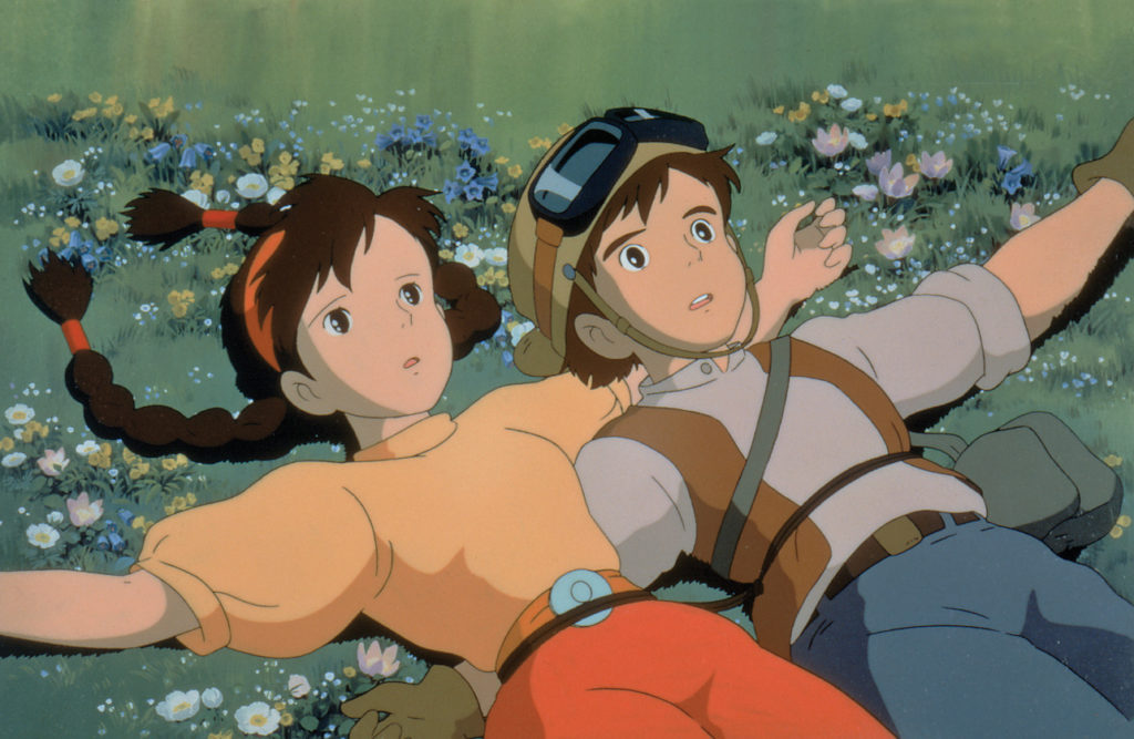 Sheeta and Pazu relax for a moment in a field of flowers after discovering the legendary floating castle in a scene from the 1986 theatrical anime film, Castle in the Sky.