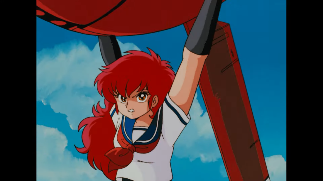 A-ko Magami hoists a giant robot over her head and prepares to lob it at another giant robot in a scene from the 1986 Project A-ko theatrical anime film.