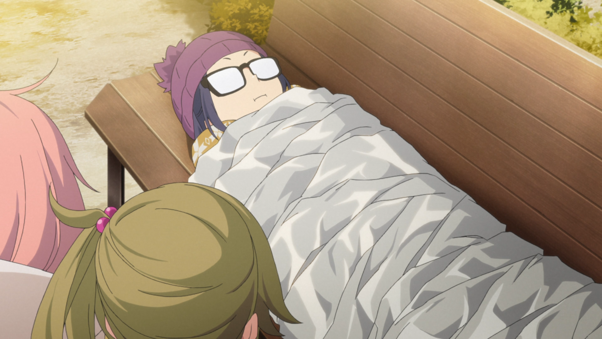 Chiaki Ogaki, Nadeshiko Kagamihara, and Aoi Inuyama of the Outdoor Activities Club attempt to turn a thin summer camping blanket into an insulated winter camping blanket with a copious application of bubble-wrap, aluminum foil, and cardboard in a scene from the 2018 Laid-Back Camp TV anime.