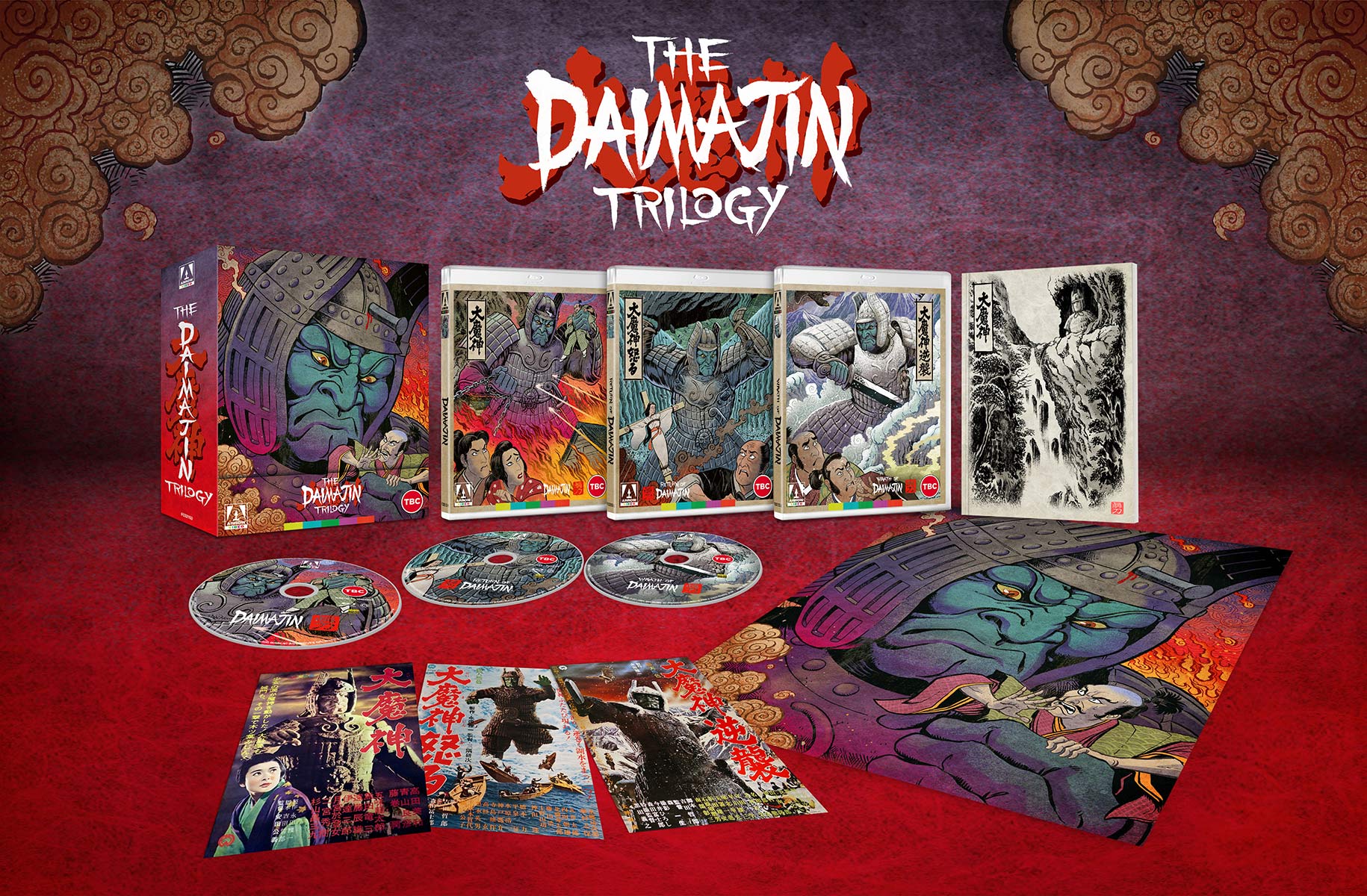 A promotional image for The Daimajin Trilogy Blu-Ray release from Arrow Films, highlighting the artwork of the box set, the cases, the discs, and the pack-in materials.