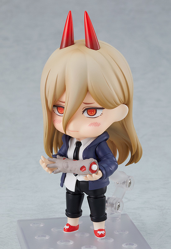 Ein Werbebild des Nendoroid Power-Spielzeugs von Good Smile Company, das verlegen aussieht, als sie an einem abgetrennten Zombie-Arm knabbert.