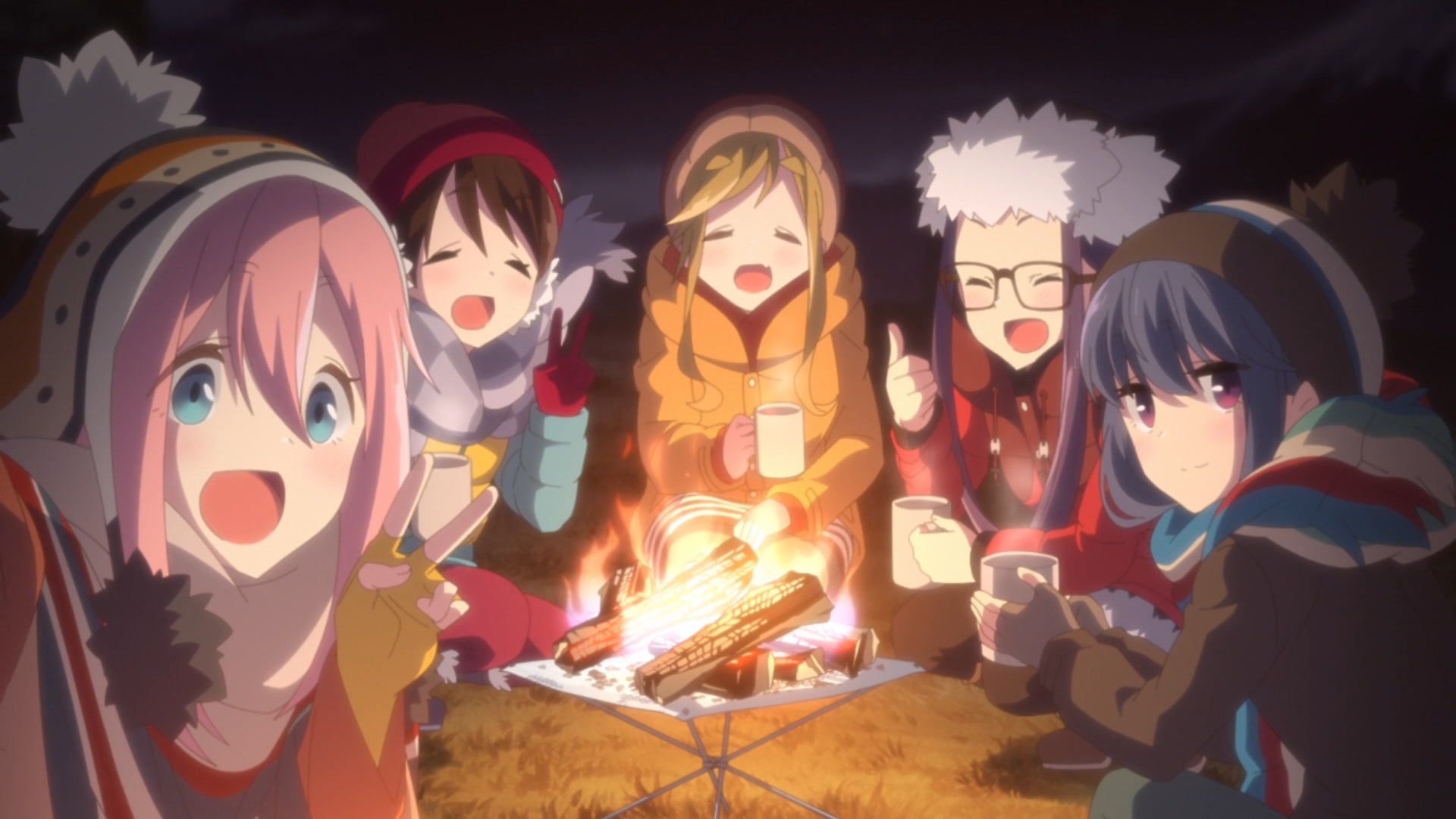 Nadeshiko, Ena, Aoi, Chiaki, and Rin enjoy hot coco around a campfire at night in a scene from the 2018 Laid-Back Camp TV anime.