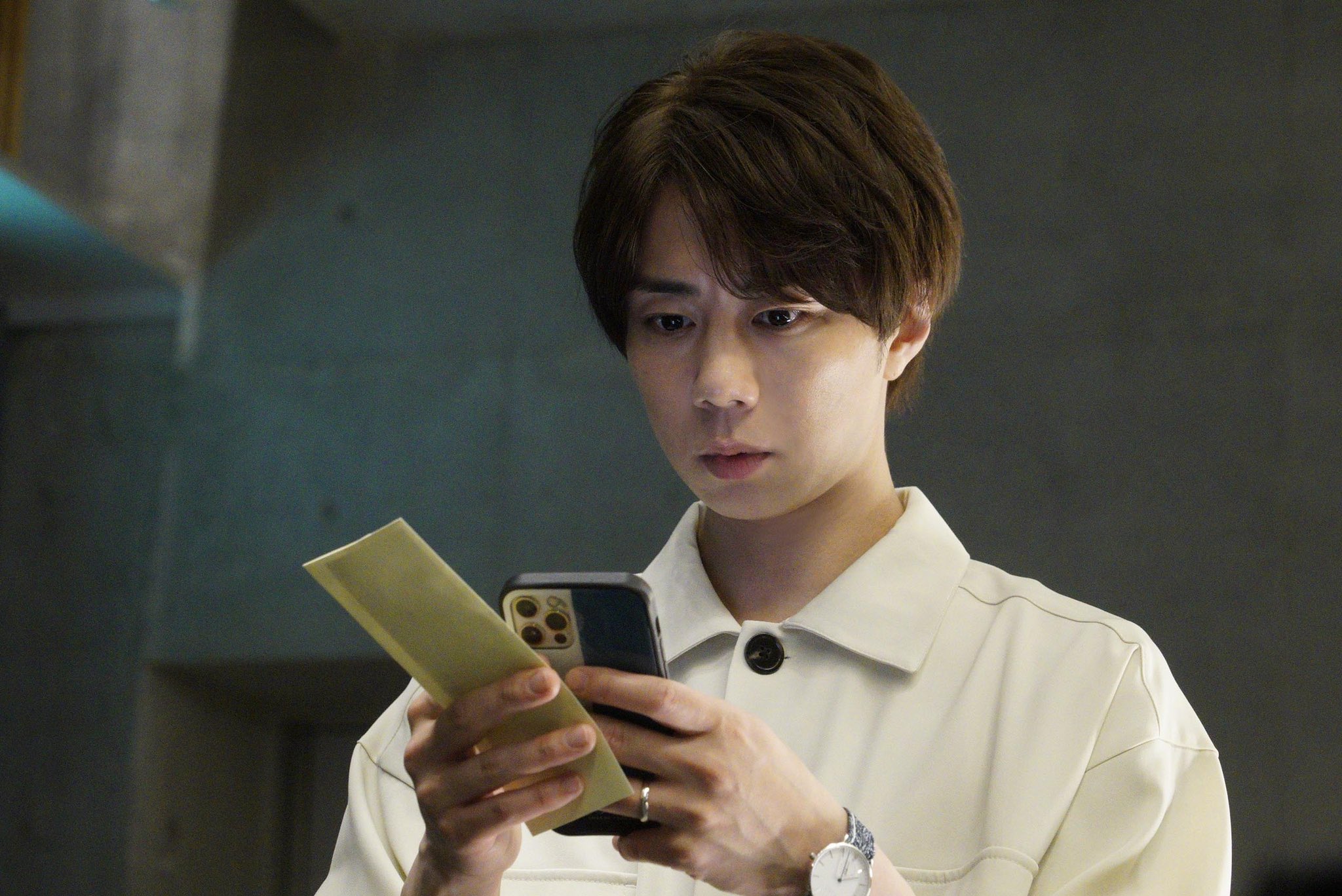 Der Webdesigner Takuya Yamanabe (gespielt vom Schauspieler Hiromitsu Kitayama) scrollt in einer Szene aus dem kommenden Film mit einem besorgten Gesichtsausdruck durch eine verdächtige Smartphone-App "Otodokemono" Segment für das Live-Action-TV-Programm „Tales of the Unusual“ im Sommer 2022.