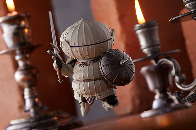 A promotional image of the Good Smile Company Nendoroid Siegmeyer toy, featuring a figure of the valiant Knight of Catarina leaping into battle with his zweihander sword and spiked pierce shield held at the ready.