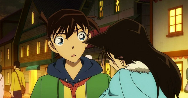 A screen capture from the Case Closed: Episode One TV special, featuring a teenage Shinichi Kudo and Ran Mori in an urban setting at night.