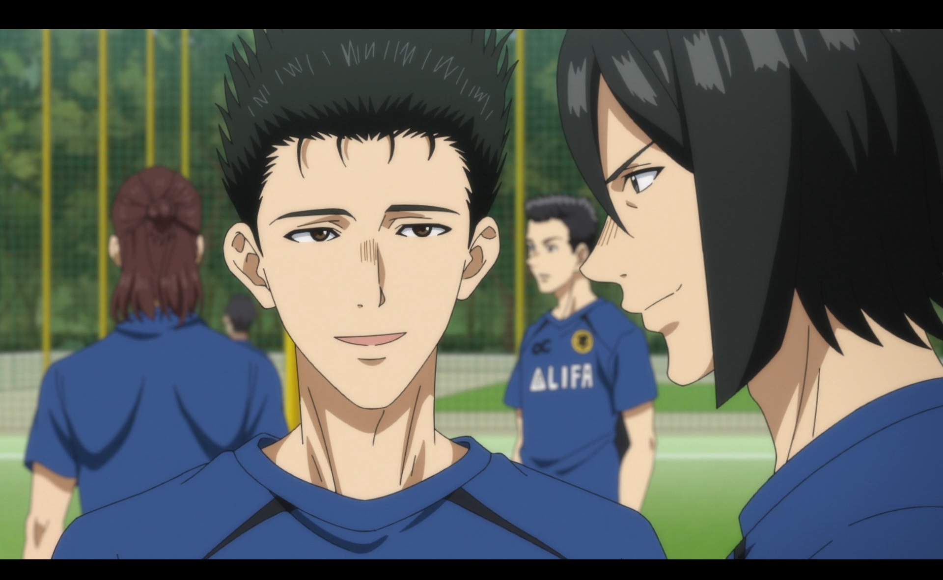 Haruhisa Kuribayashi chats with a fellow soccer player during a practice training session in a scene from the Aoashi TV anime.