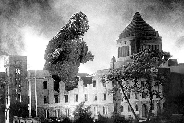 A promotional image from the original 1954 Gojira film, directed by Ishiro Honda, featuring the iconic movie monster attacking the National Diet Building.