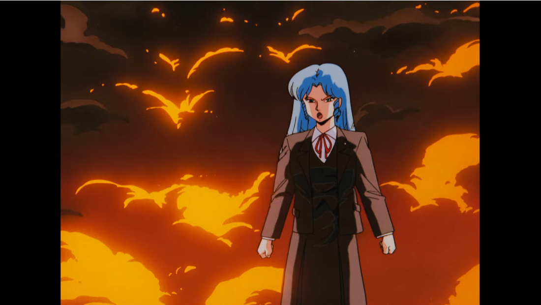 C-ko Daitokuji poses dramatically in front of the smoke and billowing flames of her failed robot creations in a scene from the 1986 Project A-ko theatrical anime film.