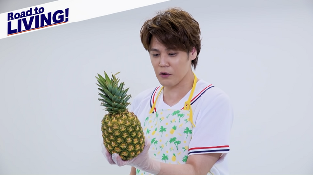 Voice actor Mamoru Miyano attempts to peal a pineapple from scratch in a scene from his new "Road to LIVING!" Youtube series.