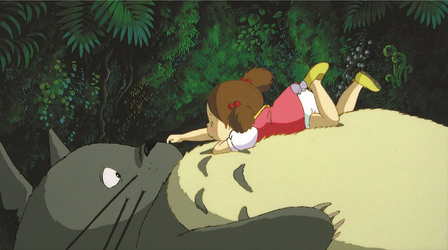 Mei and Totoro share a quiet moment in the woods in the beloved children's film, My Neighbor Totoro.