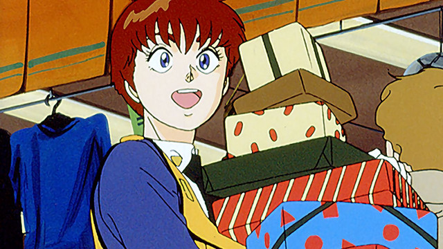 Noa Izumi is laden with packages at shopping mall in a scene from the Patlabor the Mobile Police TV series.