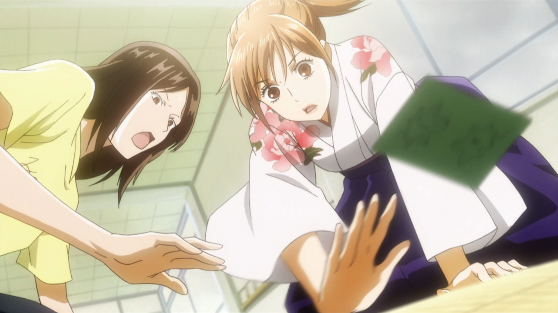 Chihaya Ayase reclama una carta en un juego de karuta competitivo en una escena del anime de televisión Chihayafuru.