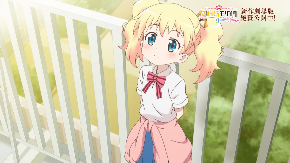 Alice Cartelet stares into the sky and smiles while leaning on a fence overlooking the school courtyard in a scene from the Kiniro Mosaic Thank You!! theatrical anime film.