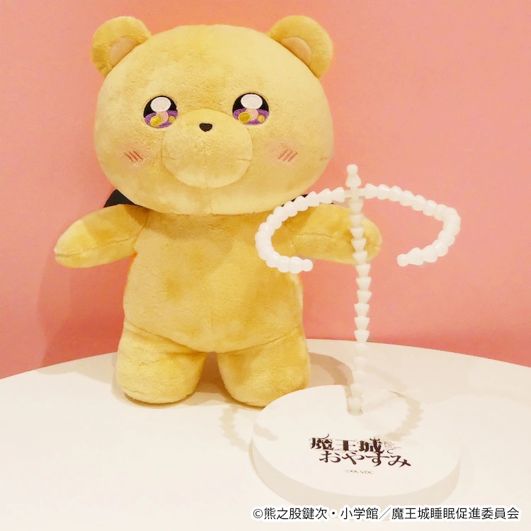 A promotional image of FuRyu's Sleepy Princess in the Demon Castle Teddy Demon Poseable Plush Toy featuring a front view of the toy and its special edition stand.